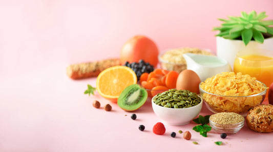 Vegetarian breakfast. Soft boiled egg, oat flakes, nuts, fruits, berries, milk, yogurt, orange, banana, peach on pink background