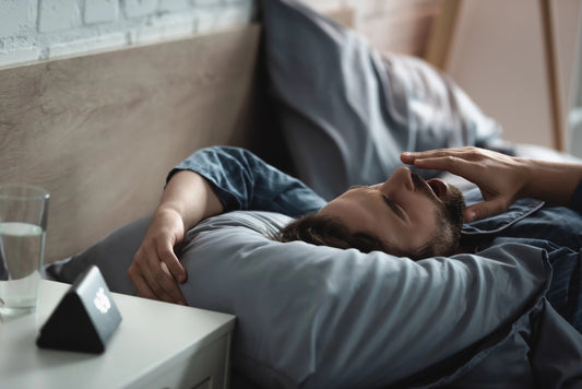 Young man yawning while lying on bed in morning