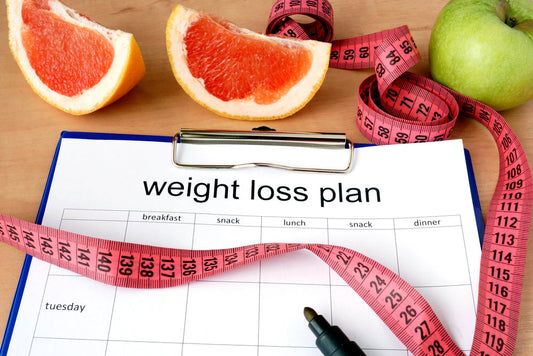 Paper with weight loss plan and grapefruit 