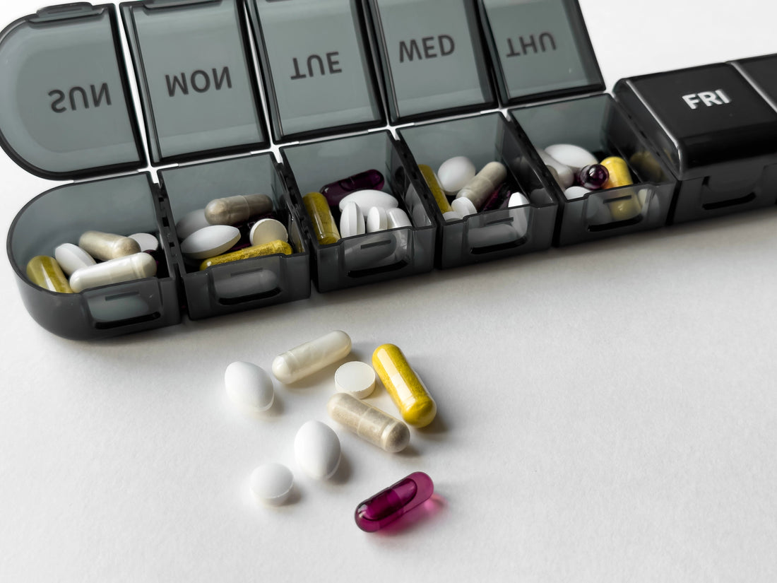 Organized weekly pill box with assorted medications and supplements
