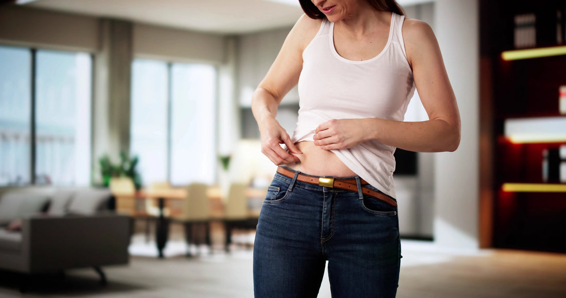 Woman sitting on toilet holding her stomach