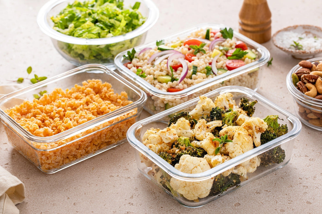 Healthy vegan meal prep with roasted vegetables, cooked lentils, couscous salad and mixed nuts