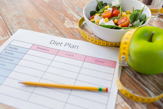 Close up of diet plan and food on table